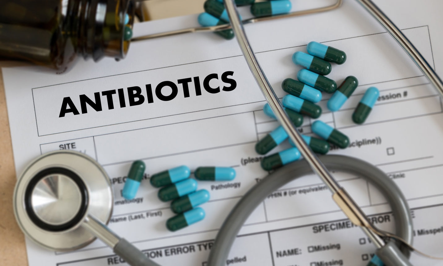 Antibiotic capsules on top of paper medical record